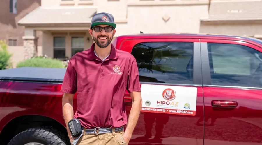 Home Inspector craig Bachler wearing a Red Home Inspection Professionals of Arizona Uniform Standing Next to red home inspection truck with HIPOAZ branding on the side.